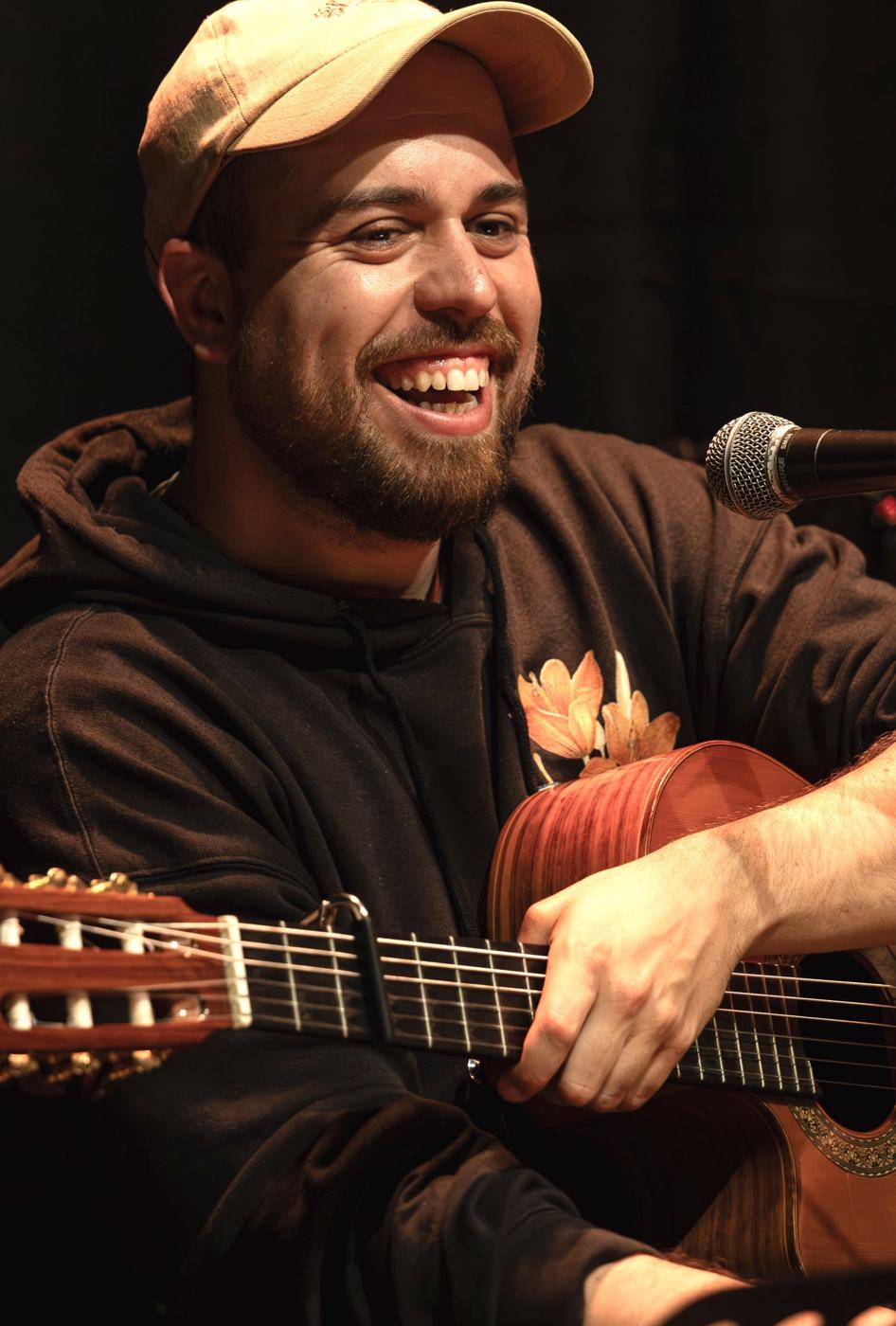 Rosán lacht mit Gitarre im Arm